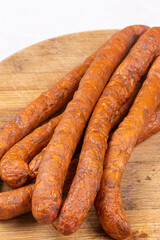 Fresh raw smoked sausages on the wooden cutting board