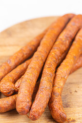 Fresh raw smoked sausages on the wooden cutting board