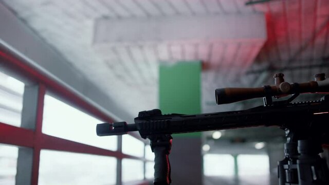 Killer with sniping rifle at urban building. Sniper targeting scope on gun