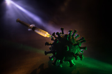 Coronavirus 2019-nCov novel coronavirus concept. Big Corona virus miniature model on wooden table with fog and backlight. Creative artwork decoration. Selective focus.