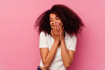 Young african american woman isolated on pink background laughing about something, covering mouth with hands.