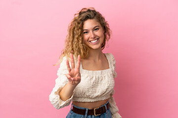 Young blonde woman isolated on pink background happy and counting three with fingers