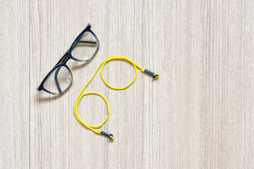 Clear eyeglasses, Glasses transparent dark blue frame with yellow eyeglasses strap on a wooden...