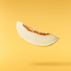 Fresh raw melon falling in the air isolated on yellow