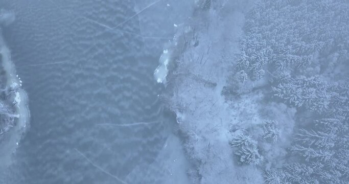 Scandinavian winter forest and lake flyover