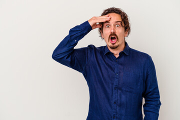 Young caucasian man isolated on white background looking far away keeping hand on forehead.