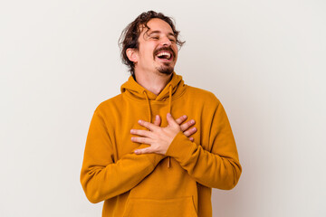 Fototapeta na wymiar Young caucasian man isolated on white background laughing keeping hands on heart, concept of happiness.