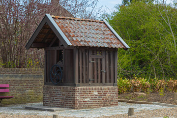 Fototapeta na wymiar Former water well in the center of an village in south Limburg, Netherlands. These typical wells can be found around the area supplying people with water in ancient times.
