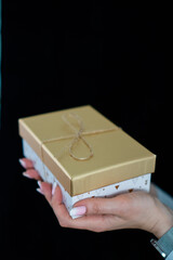 girl with manicure holding a gold gift
