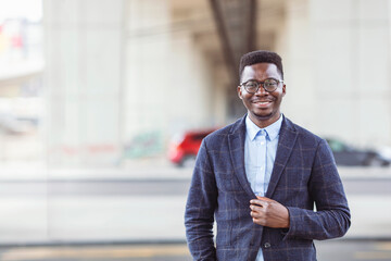 Portrait of smiling businessman. Handsome young man in eyeglasses looking at camera. Concept of confidence. Young African businessman exploring the city