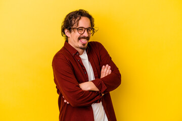 Fototapeta premium Young caucasian man isolated on yellow background funny and friendly sticking out tongue.