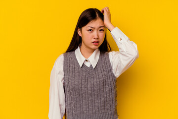 Young chinese woman isolated on yellow background forgetting something, slapping forehead with palm and closing eyes.