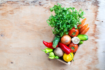 Fresh Vegetables in basket on wooden table. Top view.