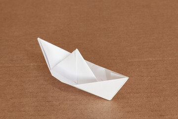 Paper boat on cardboard surface