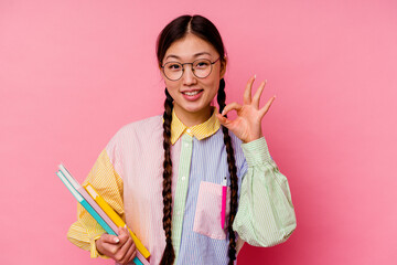 Young chinese student woman holding books wearing a fashion multicolour shirt and braid, isolated...