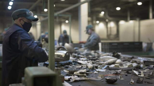Male workers sort and recycle electronic waste and scrap metal