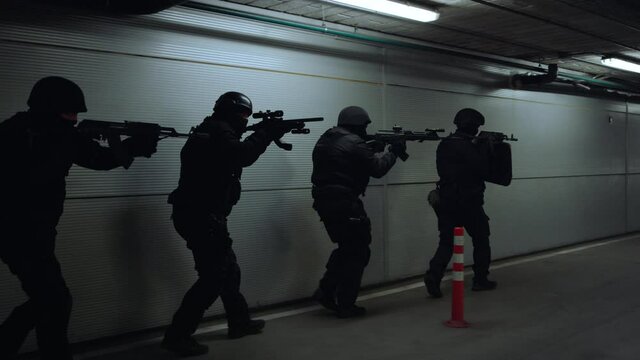 Special ops police team shooting with rifles. Soldiers examining building 