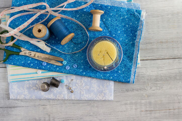 Blue fabrics  and sewing accessories for needlework.