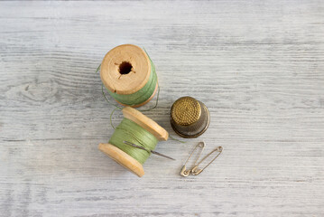 Spools with green thread, needle and thimble - tailor's set.