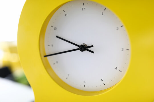 Beautiful yellow clock stands the table close-up