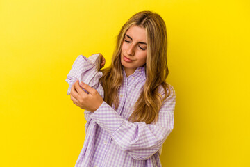 Young blonde caucasian woman isolated on yellow background massaging elbow, suffering after a bad movement.