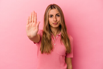 Young blonde caucasian woman isolated on pink background standing with outstretched hand showing...