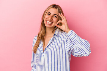 Young blonde caucasian woman isolated on pink background cheerful and confident showing ok gesture.