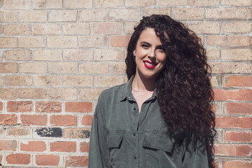 Portrait of curly hair young woman with urban style, latin style, arabic style