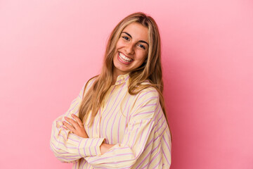 Young blonde caucasian woman isolated on pink background laughing and having fun.