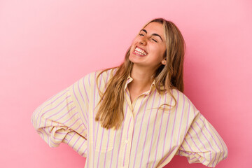 Fototapeta premium Young blonde caucasian woman isolated on pink background relaxed and happy laughing, neck stretched showing teeth.