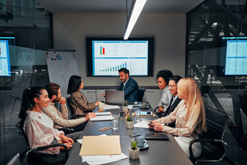 A multiethnic group of young people at a business meeting sit at a table and discuss work. Business...