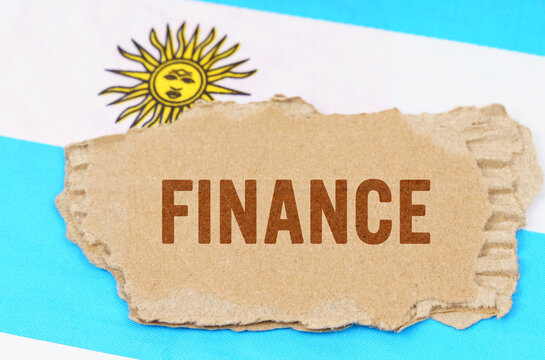 Against the background of the flag of Argentina lies cardboard with the inscription - finance
