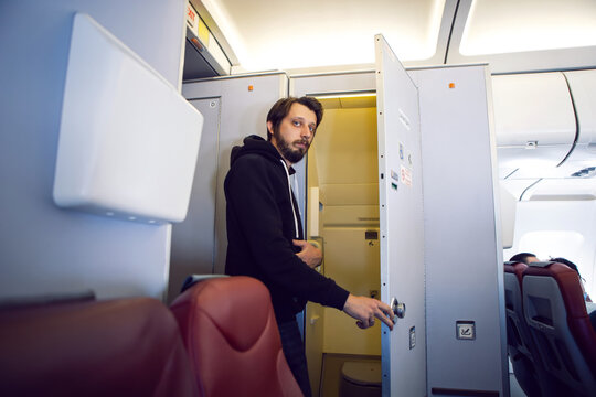 Man In Black Clothes Goes To The Toilet On The Plane