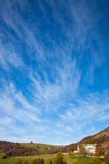 paesaggio montano verticale con nuvole a strisce e pennellate