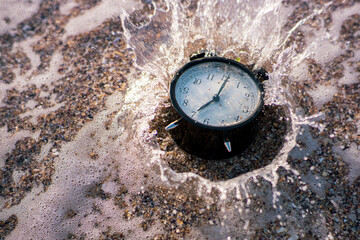 Alarm clock splashing in the beach water