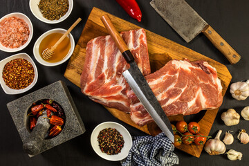 Raw Pork ribs with a spice. Raw meat on the kitchen board. Preparation of marinade from honey and chili peppers. Summer barbecue.