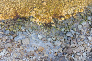 Large stones on the seashore, coastline and clear sea water. View from above.