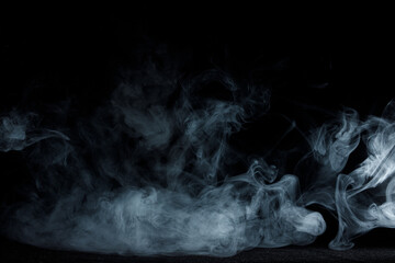 Abstract white smoke moves on black background. Beautiful swirling gray smoke.