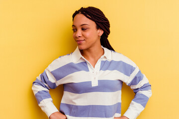 Young african american woman isolated on yellow background dreaming of achieving goals and purposes