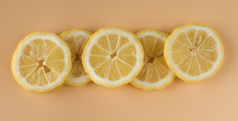 Pieces of lemon, Lemon sliced into slices on a background of apricot color in isolation