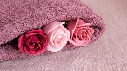 Obraz na płótnie Canvas Floral fragrant soap roses and lilac terry towel for a shower. Aroma and purity of the body.