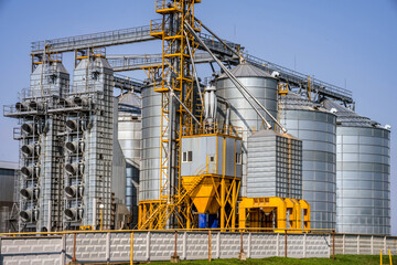 Modern Granary elevator. Silver silos on agro-processing and manufacturing plant for processing drying cleaning and storage of agricultural products, flour, cereals and grain. seed cleaning line