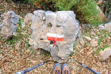 red and white hiking trail marker  on rock