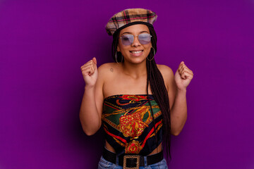 Young african american woman isolated on yellow background Young african american woman isolated on yellow background raising fist, feeling happy and successful. Victory concept.