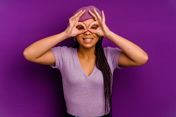 Young african american woman isolated on yellow background Young african american woman isolated on yellow background showing okay sign over eyes