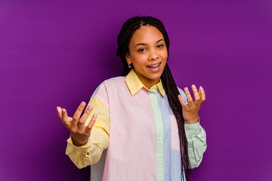 Young african american woman isolated on yellow background pointing with finger at you as if inviting come closer.