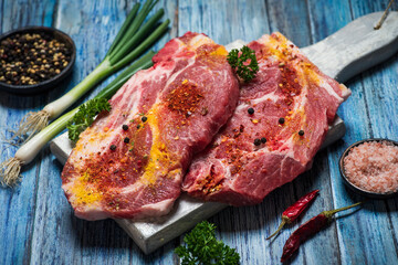 Raw pork meat slice on a wooden table tabletop view