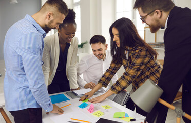 Office workflow planning organization or training process concept. Mixed race diverse creative business team or high student group brainstorming developing plan using color sticker labels for notes