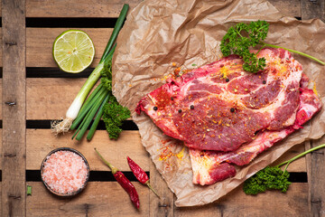 Raw pork meat slice on a wooden table tabletop view