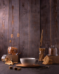 A cup of tea and jars of bouncing cookies on a background of brown boards. Breakfast at the village house. Place for your text.